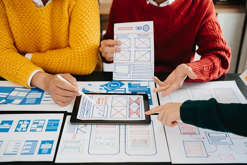 Team bei Workshop/Planung, Wireframes auf Bildschirm oder Whiteboard, professionelle Arbeitsatmosphäre